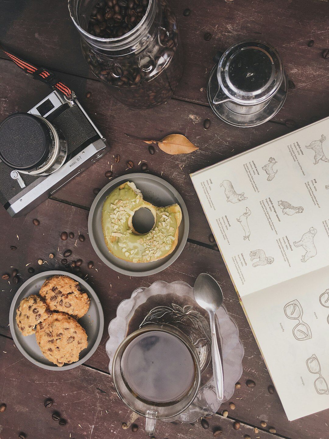 Overhead flat lay of a detective notebook, magnifying glass, old photographs and black coffee